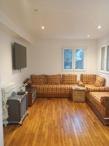 un salon avec un canapé et une télévision à écran plat dans l'établissement La Citadelle, à Arcueil