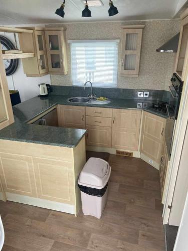 a kitchen with a sink and a trash can at PG101 6 BERTH DELUXE ON THE GOLDEN PALM CHAPEL st LEONARD PG101 in Chapel Saint Leonards