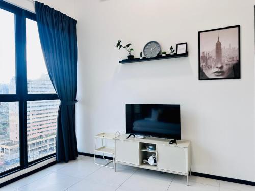 a living room with a tv and a large window at New Comfy Urban Suite Homestay at Georgetown for family by Urban Staycations LOD in Jelutong