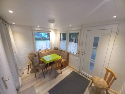 a dining room with a green table and chairs at Monteur- Ferienwohnung für 5 Pers Gartenhaus in Märkisch Buchholz