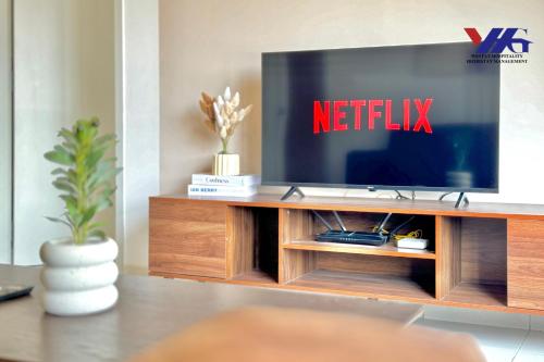 a living room with a television on a entertainment center at Alanis Suite With Netflix @ KLIA Sepang in Sepang