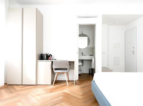a bedroom with white walls and a chair in front of a table at Mamas in Oristano