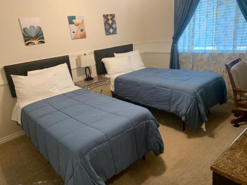 a bedroom with two beds and a chair and a window at LuxHome Suites in Mansion in Riverside