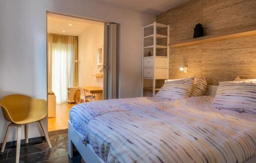 a bedroom with a large bed and a chair at Bambou Rooms in Vrouwenpolder