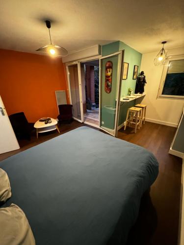 a bedroom with a bed and a room with a desk at le loft Geek in Toulouse