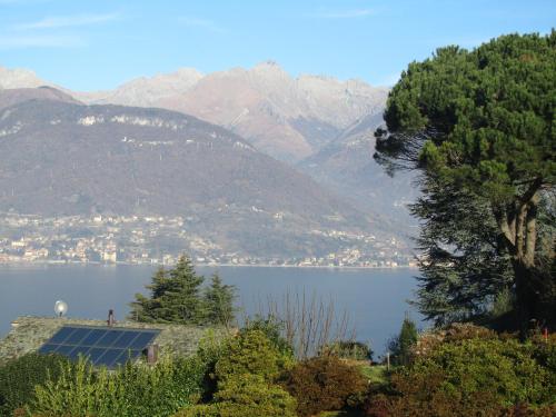 a view of a lake with a house and mountains at Albergo Ristorante Conca Azzurra in Colico