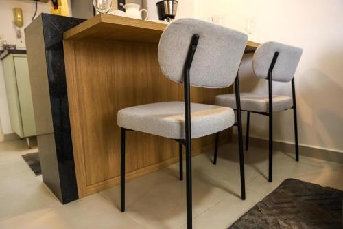 two chairs sitting next to a counter in a kitchen at FLATS - DUO JK in Sao Jose do Rio Preto