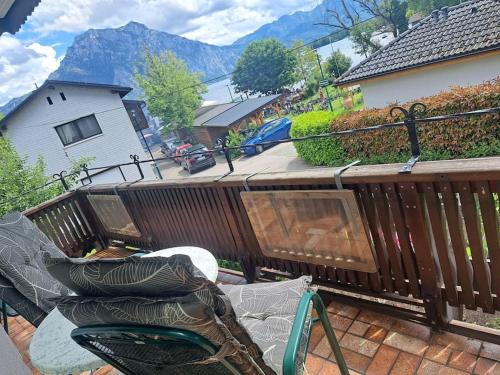 a balcony with a wooden deck with chairs on it at Ferienwohnung direkt am See 4 in Altmünster