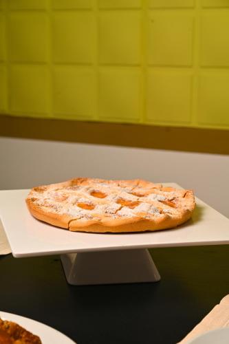 a pizza sitting on a white plate on a table at Ghe kalè Resort in San Paolo Bel Sito