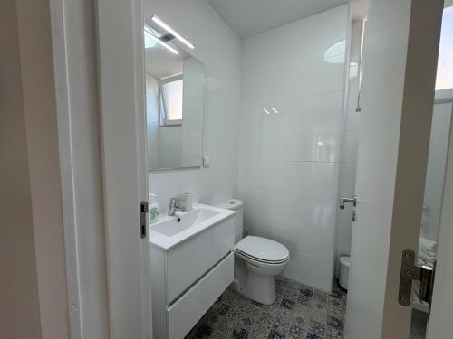 une salle de bains blanche avec toilettes et lavabo dans l'établissement Estoril Escape - Family & Friends Beach Getaway, à Estoril
