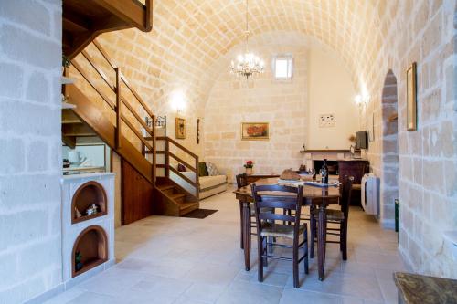 een eetkamer met een tafel en stoelen en een trap bij Casa Vittoria in Matera