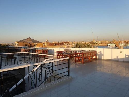 a patio with tables and benches on a roof at Villa Omar El Sharif Appartement studio n2 in Luxor