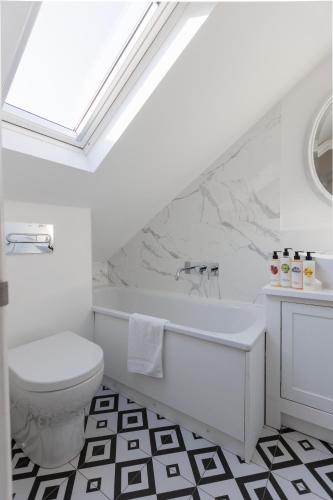 a white bathroom with a tub and a toilet at Beautiful Oxford Town House in Oxford