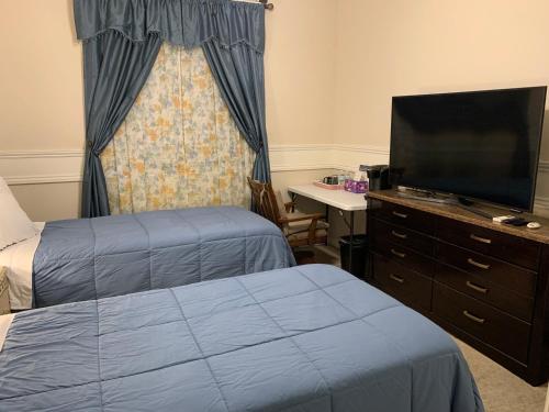 a hotel room with two beds and a flat screen tv at LuxHome Suites in Mansion in Riverside