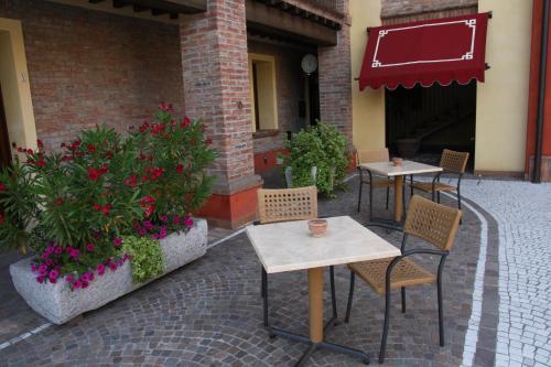 two tables and chairs on a patio with flowers at Luna Residence Hotel in Casalmaggiore