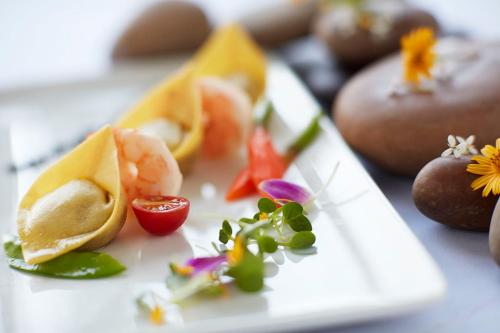 a white plate with some food on a table at Vivanta Guwahati in Guwahati