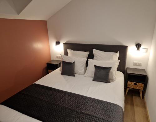 a bedroom with a large white bed with pillows at domaine de saint jacques devant bruyères in Vienville