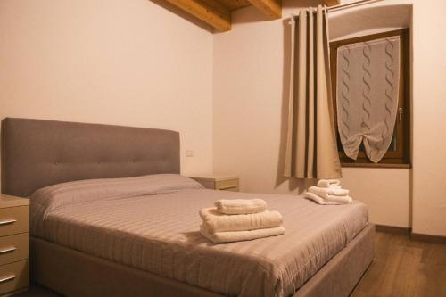 a bedroom with a bed with towels on it at Casa Cerí in Bagolino