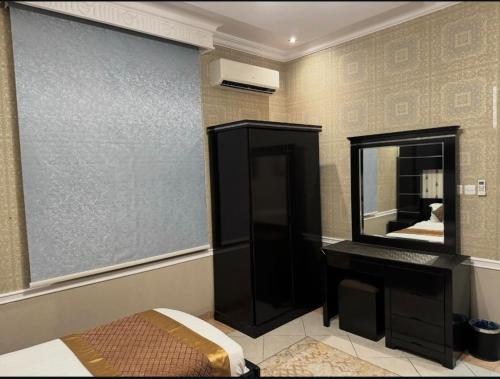 a bathroom with a mirror and a bed and a vanity at قصر الروابي للشقق المخدومة اقتصادي in Riyadh