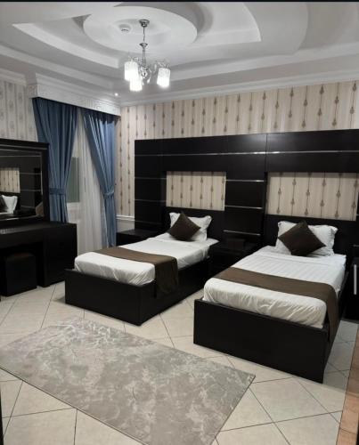 a bedroom with two beds and a piano at قصر الروابي للشقق المخدومة اقتصادي in Riyadh