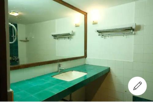 a bathroom with a sink and a large mirror at Calangute Candolim Beach Bay villas and Apartments in Baga