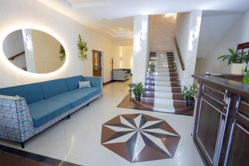 a living room with a blue couch and a staircase at Fantasia Hotel in Polyana