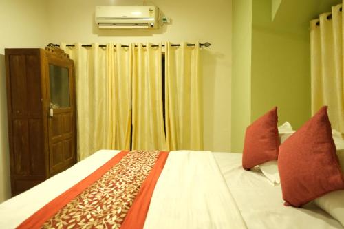 a bedroom with a bed with red pillows at Calangute Candolim Beach Bay villas and Apartments in Baga