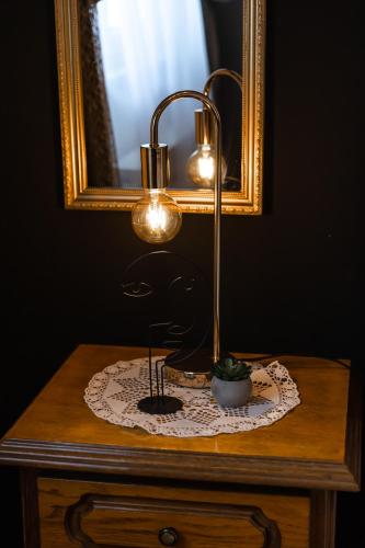 a lamp on top of a table with a mirror at Deluxe Apartment RoMa in Imotski