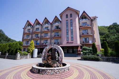 a building with a fountain in front of a building at Fantasia Hotel in Polyana