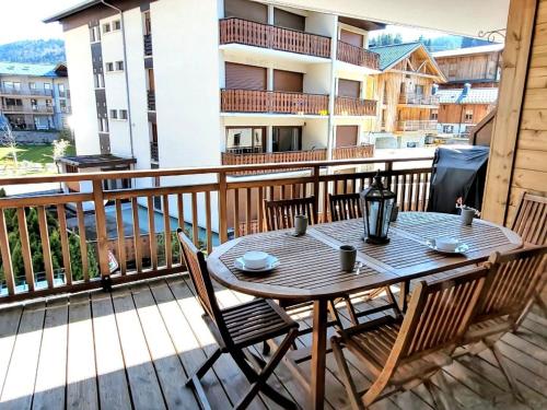 une table et des chaises en bois sur un balcon dans l'établissement Appartement 4 étoiles aux Gets avec 2 chambres, cabine et terrasses, proche centre et pistes de ski - FR-1-598-6, aux Gets