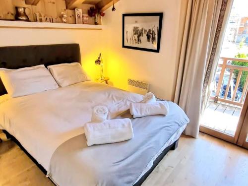 a bedroom with a large bed with towels on it at Appartement montagnard 4* cosy, 2 ch, 6 pers - FR-1-598-6 in Les Gets