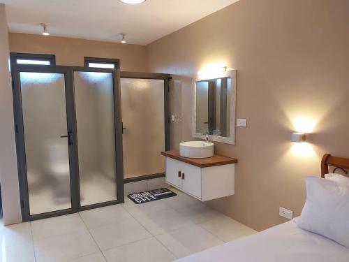 a bathroom with a sink and a shower with a mirror at Gris Gris Studio 1 in Souillac
