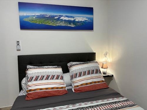 a bedroom with a bed with two pillows on it at Villa bouginvilliers in Le Tampon
