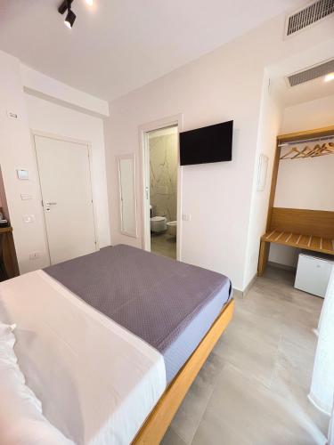 a bedroom with a bed and a tv on the wall at Le Camere Del Centro in Matera