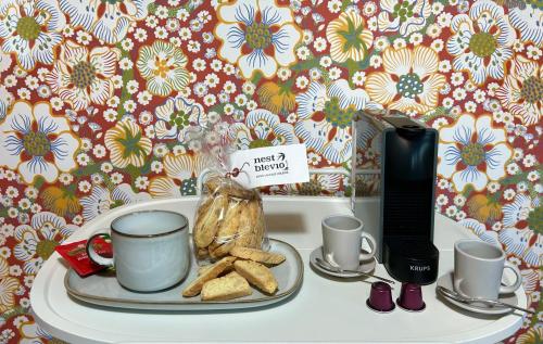 a table with a plate with coffee cups and cookies at Nest Blevio apartment with private garage in Blevio