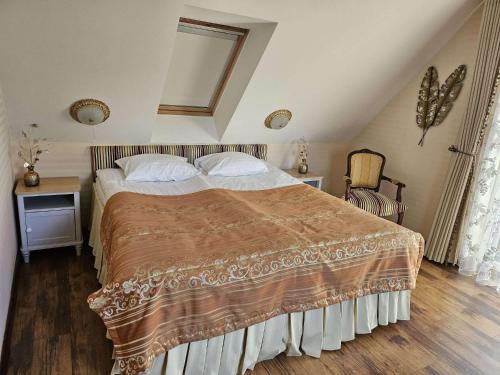a bedroom with a large bed in a attic at Vila Mažoji apartamentai in Palanga