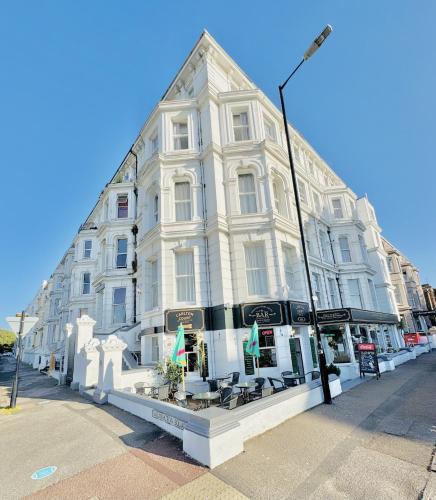 a large white building on the corner of a street at Carlton Court Hotel Eastbourne in Eastbourne