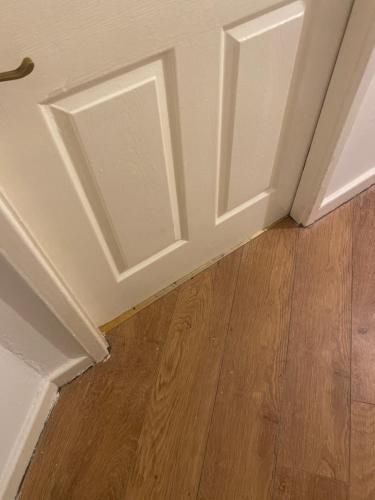 a room with white doors and a wooden floor at Jakes en suite room near James cook in Middlesbrough