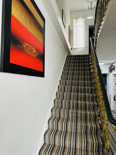 a staircase in a building with a painting on the wall at Carlton Court Hotel Eastbourne in Eastbourne