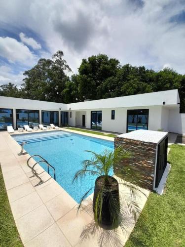 a swimming pool in front of a building at Espectacular Casa Quinta en Riachuelo Cts in Laguna Brava