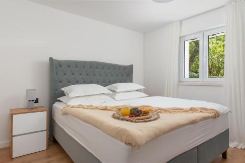 a bedroom with a bed with a tray of fruit on it at Unique Villa Pietra with heated private pool in Šestanovac