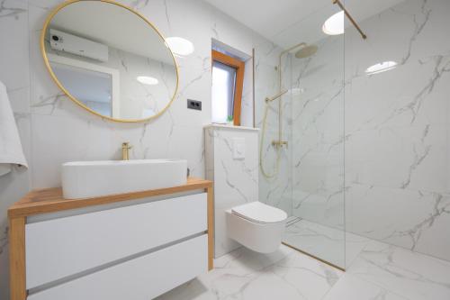 a white bathroom with a sink and a mirror at Unique Villa Pietra with heated private pool in Šestanovac