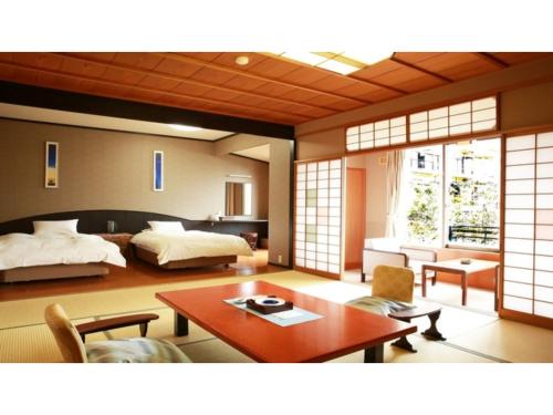 a room with a bedroom with a bed and a table at Tokigasane - Vacation STAY 15860v in Kaga