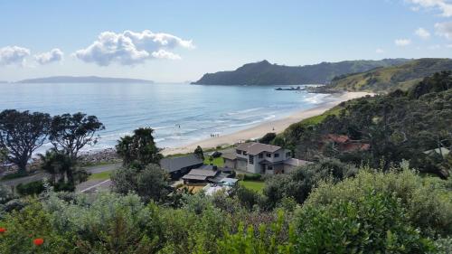 a view of a beach with a house at The Wow House in Kuaotunu