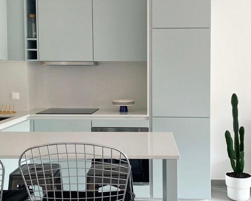 une cuisine avec des placards blancs, une table et un cactus dans l'établissement Appartement Vista Mare Sète - vues mer et étang - parking, à Sète