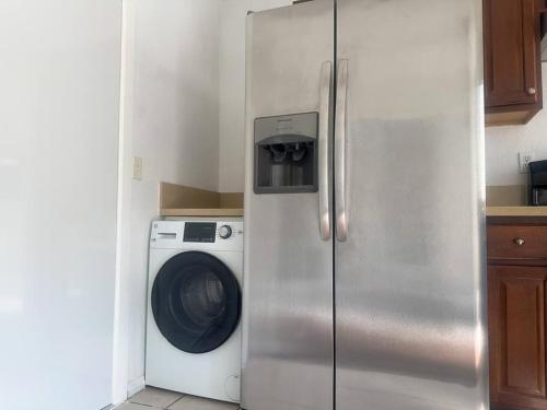 a refrigerator in a kitchen with a washing machine at Fabulous Guesthouse in Mount Helix La Mesa in Grossmont