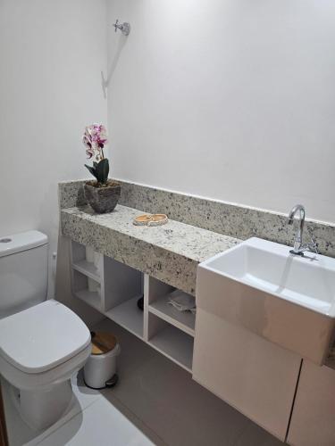 a bathroom with a sink and a toilet at Village Térreo Acqua Guarajuba in Guarajuba