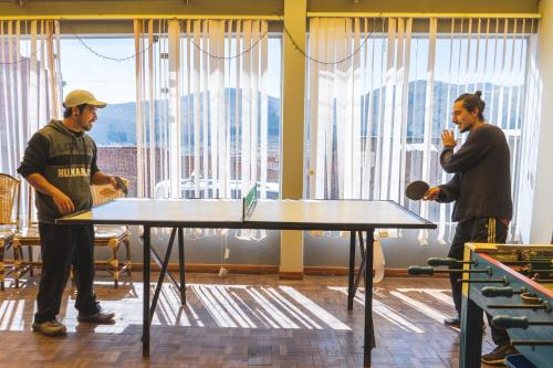 two men standing around a table in a room at Nexus Solsticio Copacabana in Copacabana
