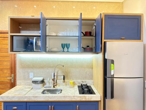 a kitchen with blue cabinets and a white refrigerator at Flat 213 Ilha Bela Alter do Chão in Alter do Chao