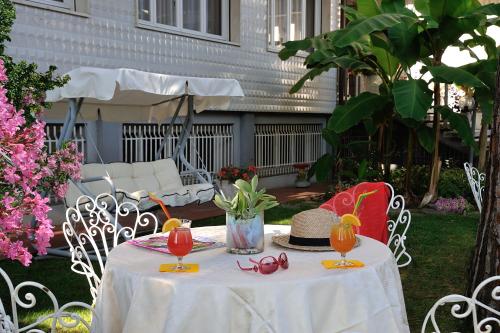 a white table with glasses and a hat on it at Corallo Wellness Hotel in Diano Marina